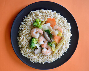 Chinese style king prawns with vegetables on a bed of brown jasmine rice.