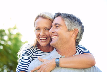Fototapeta premium Hug, love and smile with couple in park together for anniversary, bonding or romance. Adventure, piggyback or travel with mature man and woman outdoor in nature for summer holiday or vacation