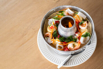 A delicious hot pot filled with steamed egg and an assortment of fresh seafood is beautifully displayed