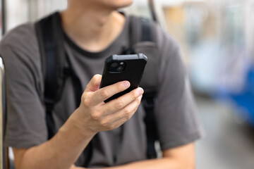 電車でスマホを見る男性