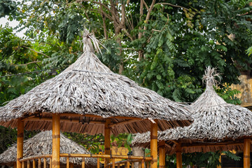 Beachside pavilion made from bamboo and dried leaves. Grass leaf palm sun umbrella or pergola
