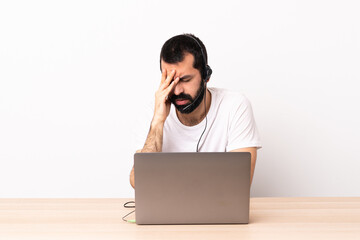 Telemarketer caucasian man working with a headset and with laptop with tired and sick expression.