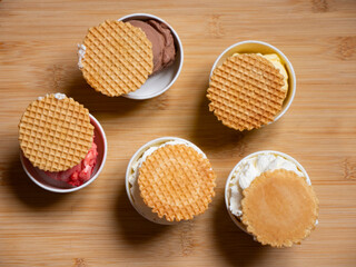 Italian ice cream in a compostable cup with waffle disk top view flat lay