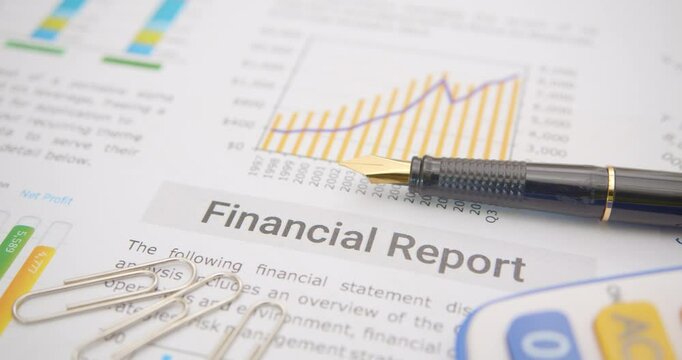 Pen atop a business or corporate financial report, anticipating review by financial and investment experts prior to public disclosure. Illustrating financial analysis and investment insight concept.
