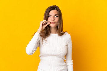 Young Slovak woman isolated on yellow background showing a sign of silence gesture