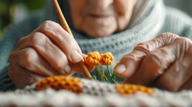 Close-up of a senior individual working on a yarn art project using a paintbrush, demonstrating precision and care. The focus is on the yarn and the meticulous craftsmanship involved.