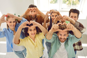 Top view portrait of a happy young smiling people making heart shape gesture standing at home....