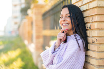 Fototapeta premium Young woman at outdoors smiling