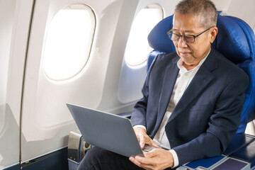 An adult male businessman sits by the window on a passenger plane, eager to travel abroad. He gazes at the clouds, anticipating new experiences and adventures in a foreign land.