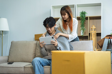 young couple helps put things in boxes and prepares, smiling happy moving to a new house.