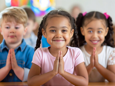 Group of diverse children praying in Sunday school