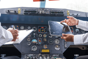 Mature male and female pilots meet inside an airplane, holding hands. Their gesture signifies...