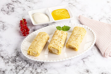 Homemade stuffed pancakes with honey and cream sour