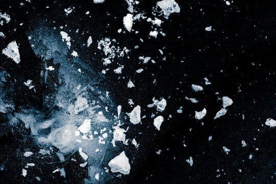Crushed ice on a black background. Shards of crushed ice spread away. The explosion of ice. Frosty texture.