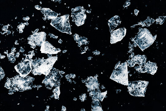 Ice, crushed on a black background. Pieces of crushed ice spread away. Crushing of the ice.