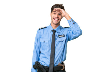 Fototapeta premium Young police man over isolated background looking far away with hand to look something