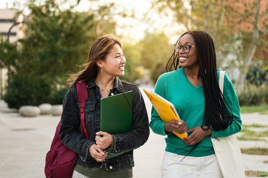International Asian and African American student girl friends walking going back to school
