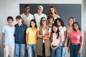 Group portrait of teenager students with senior teacher at school classroom ready to start college university