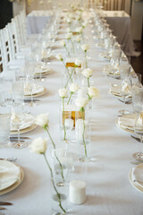 Elegant neutral coloured wedding table scape with flowers and candles