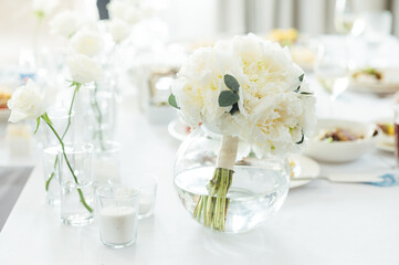Elegant neutral coloured wedding table scape with flowers and candles