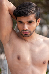 Fototapeta premium Close-up portrait of a confident, handsome, athletic Indian man, shirtless, revealing his sensual body, showcasing his rich facial expressions, exuding a calm and peaceful demeanor