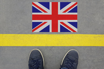 Word Start on an asphalt road with the UK flag and legs in shoes. Immigration and Travel in Great...