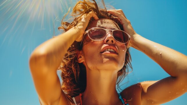 Young woman sweating hands above head stressful painful expression under extreme hot summer day Caucasian female with sunglasses