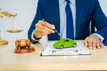 A male Asian lawyer in a formal suit works at his desk, focusing on contracts and legal matters,...