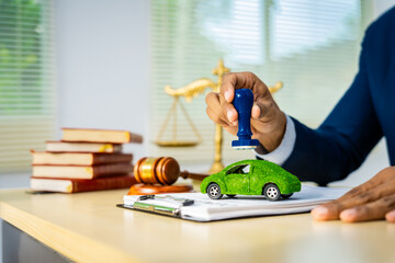 A male Asian lawyer in a formal suit works at his desk, focusing on contracts and legal matters,...