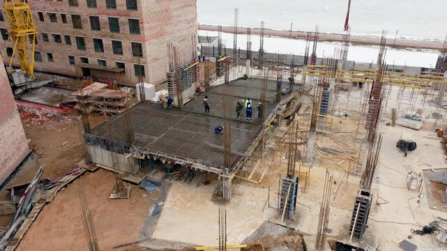 A group of construction workers and engineers build a parking lot near an apartment complex