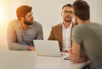 Business, team and men in office for talk, meeting and brainstorming at laptop. Professional people, proposal and profit planning at table with discussion, pitch and company development in finance