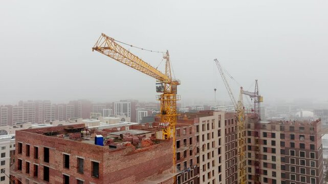 Construction in Fog Drone Shot. Tower Crane and Building Close-Up