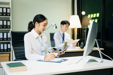 Business woman using tablet and laptop for doing math finance on an office desk, tax
