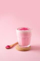 Pink matcha latte with powder on white background