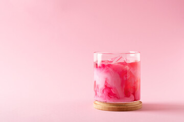 Pink matcha latte with powder on white background