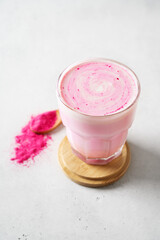 Pink matcha latte with powder on white background