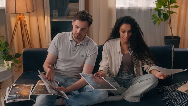 Family relocation repair home house purchase planning couple choose photos of flat interior discuss design arguing pictures conflict disagree talking Caucasian man male guy Hispanic woman female girl - Powered by Adobe