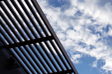 the view from below is a slatted roof and blue sky