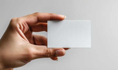 Obraz premium A close-up shot on a white background shows a man's hand holding a business card.