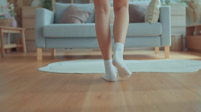 B roll - Closeup foot of young woman walking on wooden floor at home