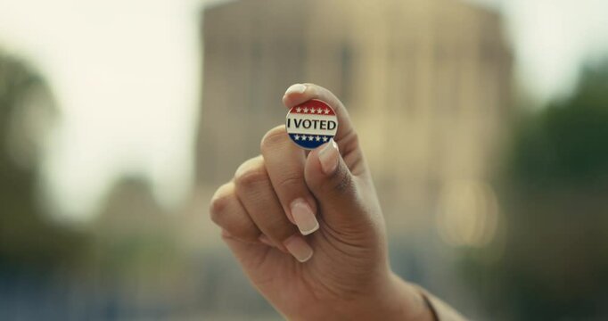 Young woman smiling with an &lsquo;I Voted&rsquo; stickers and pin 