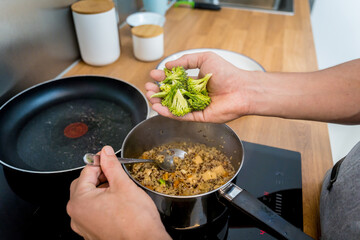 Chef at the kitchen preparing healthy quinoa bowl with avocado