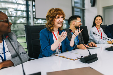 Woman CEO talking on the microphone on meeting with her colleagues about business plan, future collaboration.