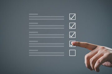 Close-up of hand completing a checklist with checkboxes on a dark background. Concept of task management, productivity, and organization.