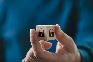 Hand holding a cube with padlock icons. Concept of security, data protection, and encryption.
