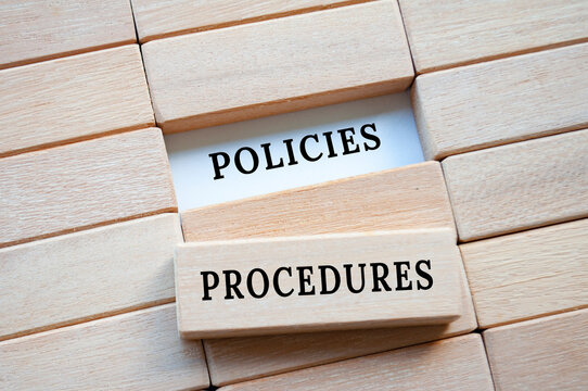 Policies and procedures on wooden blocks. Company's policies and procedures concept.