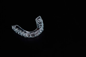 A clear mouth guard is placed on a black tabletop