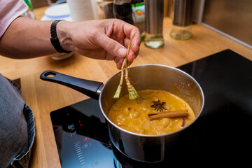 Chef at the kitchen preparing massaman curry with sweet potato and many spices