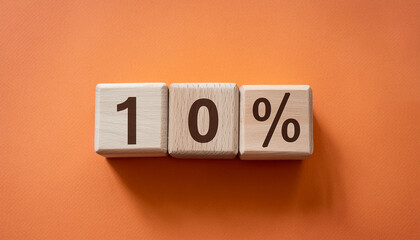 Wooden cubes with text 10% on orange backdrop. Wood blocks, ten percent. Close-up. Flat lay