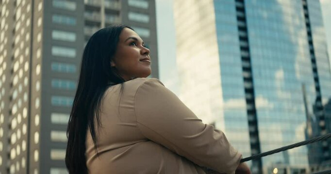 Young woman admiring downtown city buildings and scenery during sunset